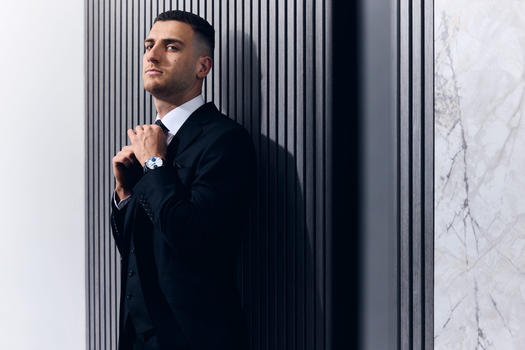 Diogo Dalot wearing a black suit and watch