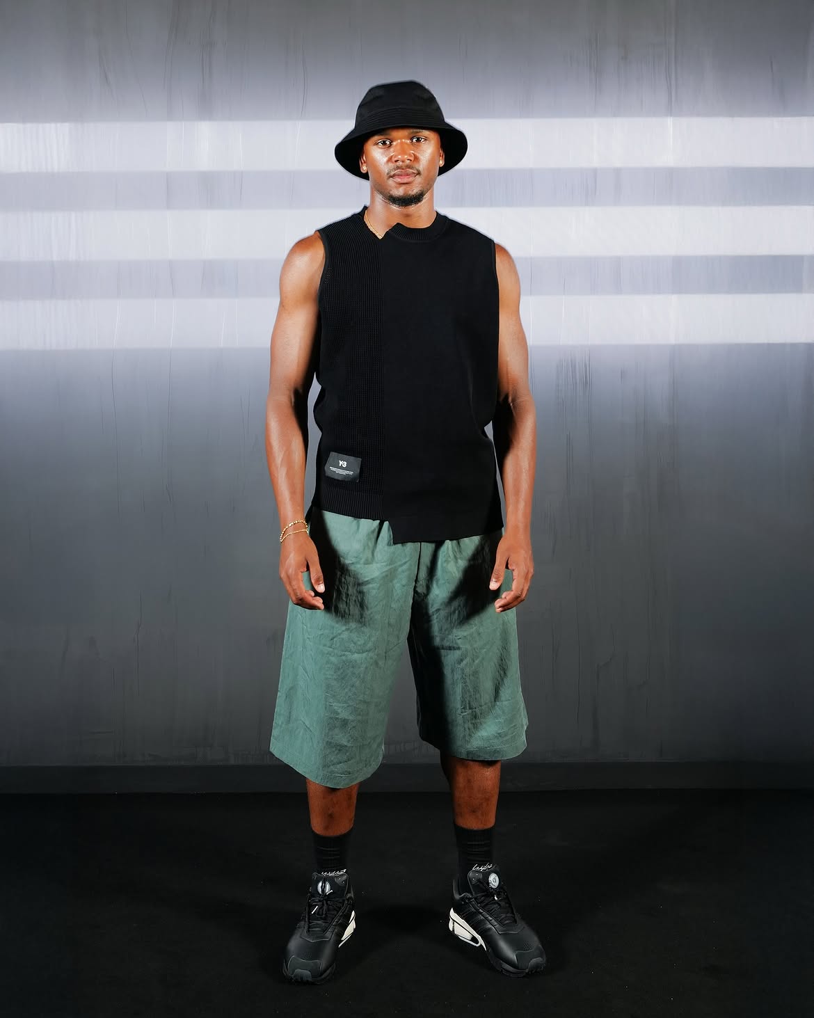Loïs Openda wearing a black bucket hat and green shorts